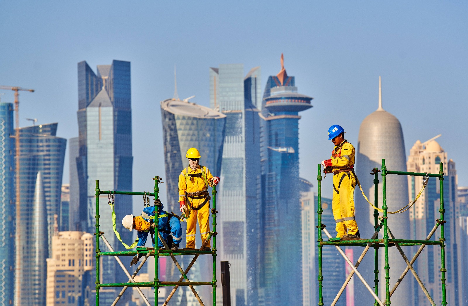 Imagine din Qatar înaintea Mondialului: muncitori cu zgârie-norii din Doha în fundal Foto: Imago